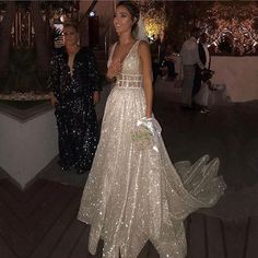 two women standing next to each other at a formal event wearing dresses with sequins on them