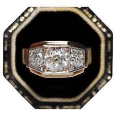 an antique diamond and gold ring, with three diamonds on each side in the center