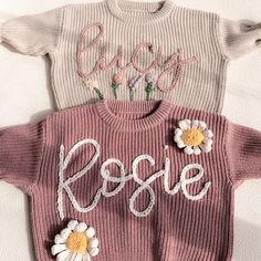 three knitted sweaters with flowers and the word rose written in white on them