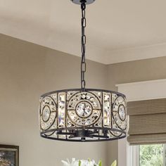 a chandelier hanging from the ceiling in a dining room with flowers on it