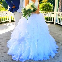 a bride and groom pose for a photo in front of a gazebo