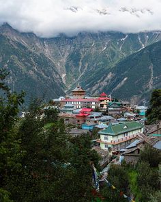 a small town nestled in the mountains under a cloudy sky