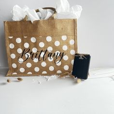 a brown bag with white polka dots on it and a cell phone next to it