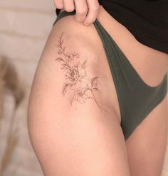 a woman with a flower tattoo on her lower back side view, showing the bottom part of her thigh