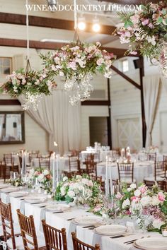 the tables are set with white linens and floral centerpieces for an elegant wedding reception