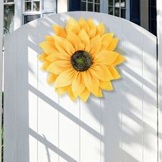 a sunflower on the side of a white fence