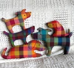 three colorful dogs are sitting on a white blanket