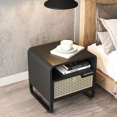 a nightstand with a cup and saucer on it next to a bed in a bedroom