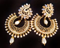 If you like something rare and artistic , which also is stylish this is the piece to own. **Pearl and Gold earrings **Chand bali style Earrings ** Kundan stones are used which makes the piece unique. ** Length of earring 3.5 inches ** Post earrings ** Lightweight as compared to what they may seem Kundan is bezel setting of gemstones in 22K gold leaf. This art form was made famous by the royals mostly during the Mughal era in India. Be a part of this legendary art by owning this piece of art. ONE Pearl And Gold Earrings, Chandbalis Earrings, Chand Bali, Earrings Kundan, Gold Chandelier Earrings, Chandbali Earrings, Bali Style, Bali Fashion, Earrings Indian