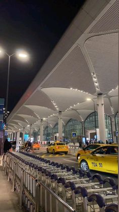 an airport terminal filled with lots of chairs and carts next to parked yellow sports cars