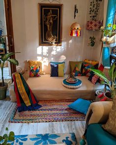 a living room filled with lots of furniture and colorful pillows on top of it's couches