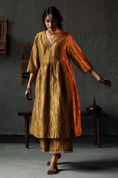 Elevate your style with exquisite tissue silk kurta and pant set, a perfect blend of traditional elegance and modern flair. Crafted from lightweight tissue silk, the kurta features a delicate sheen that catches the light with every movement, adding a touch of luxury to your ensemble. The kurta with intricate handwoven details that showcase the artistry and craftsmanship of Indian textiles. The graceful embroidery , adorns the neckline and cuffs, creating a captivating focal point. The relaxed silhouette and three-quarter sleeves ensure comfort without compromising on style. Paired with the kurta is a matching tissue silk pant that complements the ensemble beautifully. The pant features a comfortable elastic waistband and a flattering straight cut, offering a chic and versatile look. Whethe Shorshe Clothing, Tissue Suit, Silk Dress Plus Size, Gold Anarkali, Salwar Kurti, Desi Wardrobe, Haldi Outfits, Gold Suit, Silk Anarkali