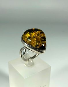 Discover the timeless elegance of our Spectacular Green Amber Ring, expertly crafted for ladies in stunning 925 sterling silver. This exquisite piece features natural Baltic Sea amber, renowned for its unique beauty and healing properties. Perfect for any occasion, this amber ring will add a touch of sophistication to your jewelry collection. Product Details: Material: 925 Sterling Silver Stone: Natural Baltic Sea Amber Color: Spectacular Green Design: Minimalist Style Ring Size: Adjustable Size Ring Weight 6,62 grams Handcrafted: Yes For: Ladies/Women Key Features: Authentic Baltic Amber: Each ring is made with genuine amber sourced from the Baltic Sea, ensuring quality and authenticity. Unique Design: The melting silver setting beautifully complements the amber, creating a one-of-a-kind Fine Jewelry Sterling Silver Ring With Polished Finish, Sterling Silver Dome Ring With Polished Finish, Teardrop Gemstone Ring For Formal Occasions, Classic Teardrop Gemstone Rings, Sterling Silver Ring With Shiny Finish, Timeless Rings With Shiny Finish As Gift, Timeless Sterling Silver Rings With Shiny Finish, Timeless Sterling Silver Ring With Shiny Finish, Timeless Shiny Finish Rings For Gifts