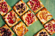 several square desserts with fruit and nuts arranged on a green tablecloth, top view