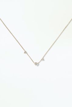 a diamond necklace on a white surface with the word love spelled in small letter charms