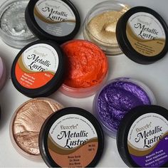 several different colors of metallic luster in small jars