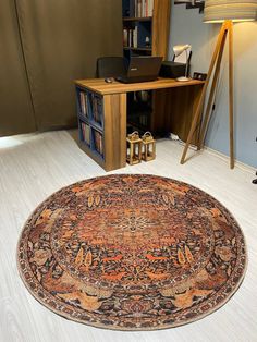 a large rug is on the floor in front of a computer desk and bookshelf