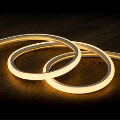 three circular lights sitting on top of a wooden table next to a black wall and wood floor