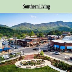 an aerial view of a small town with mountains in the backgroung and trees