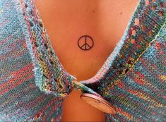 a woman with a peace sign tattoo on her chest