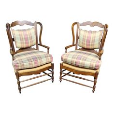 a pair of chairs with plaid upholstered cushions