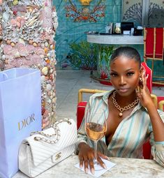 a woman sitting at a table with a glass of wine