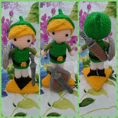 crocheted doll with green hat and boots sitting on flowered surface next to flowers