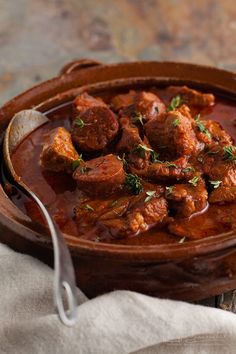 a wooden bowl filled with meat and sauce