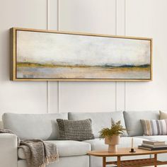 a living room with a couch, coffee table and painting on the wall above it