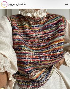 a woman wearing a multicolored knitted shawl