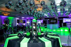 a table set up for a party with green and silver decorations