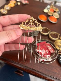 a person is holding some pins in their hand and there are other items on the table