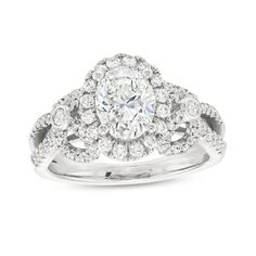 a white gold ring with an oval cut diamond surrounded by smaller round diamonds