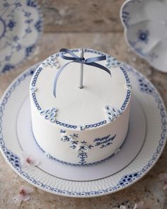 a white cake with blue flowers and a cross on top is sitting on a plate