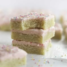 three pieces of cake with pink frosting and sprinkles