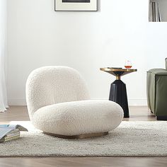 a white chair sitting on top of a rug in a living room next to a table