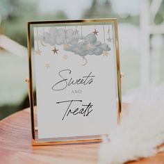 a card that says cards and gifts on top of a wooden table with white feathers