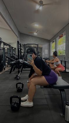 a woman sitting on top of a bench in a gym