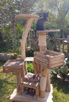 a cat sitting on top of a tree house made out of wooden pallet boards