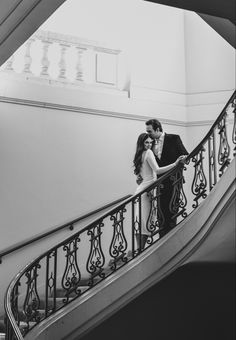 black and white photo of bride and groom kissing on the stairs at their wedding reception