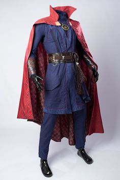 a man dressed as doctor strange standing in front of a white background wearing a red cape