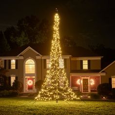 a lighted christmas tree in front of a house