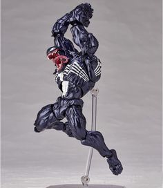 a figurine is posed on a metal stand