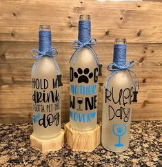 three wine bottles with blue ribbon tied around them