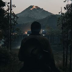 a man with a backpack looking at the mountains