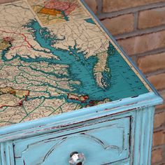 an old dresser with a map on it