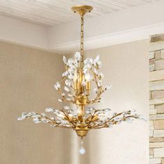 a gold chandelier hanging from the ceiling in a room with white walls and flooring