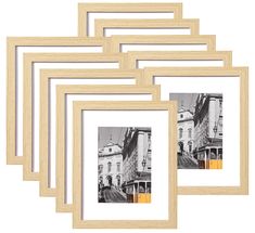 four wooden frames with black and white photos on them, each holding an image of a building