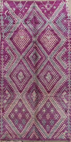 an old purple and green rug with diamonds on it