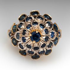 This vintage silver topped, 10K yellow gold Thai princess style ring features thirty-three (33) round cut sapphires in bead and bezel settings with milgrain edging. The ring measures 18.3mm at the top, rises 14.1mm above the finger, tapering to 2.6mm wide and 1.2mm thick at the base of the shank. The ring is currently a size 7. Antique White Gold Sapphire Ring With 17 Jewels, Victorian Sapphire Ring With 17 Jewels In 14k Gold, Antique Sapphire Ring With 17 Jewels, Blue Domed Jewelry For Anniversary, Vintage Gold Sapphire Ring With Bezel Setting, Victorian White Gold Sapphire Ring, Victorian Sapphire Ring In White Gold, Collectible 14k Gold Sapphire Ring, Victorian Sapphire Ring With Center Stone